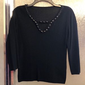 Black blouse with black bead embellishments around neck.